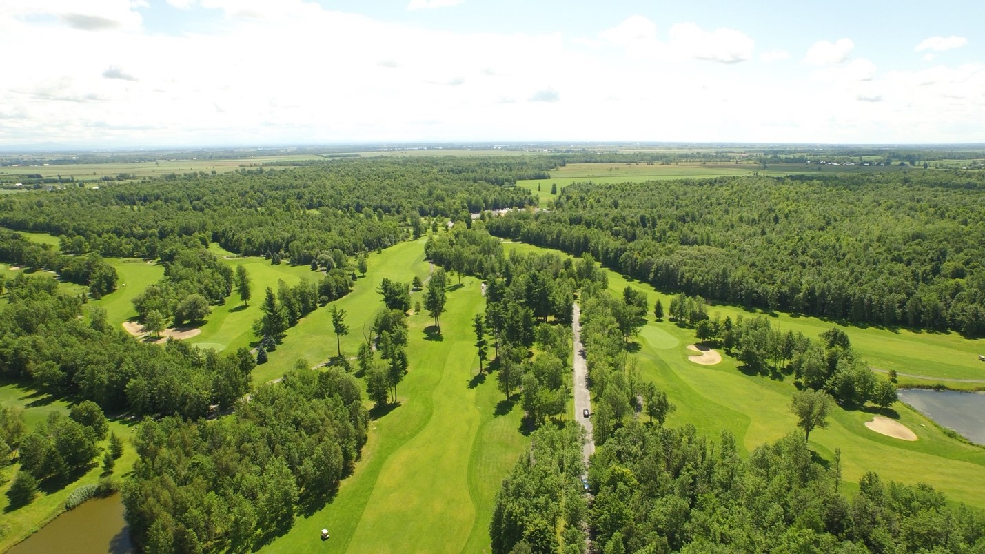 A scenic view of Golf Vallée des Forts in St-Jean-sur-Richelieu, Quebec with lush greenery and wildlife